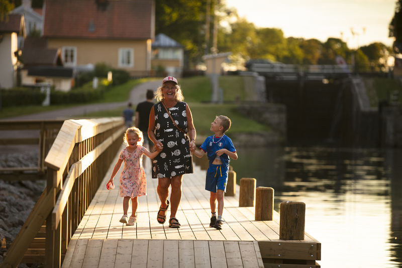 En kvinna och två barn håller varandra i handen på en brygga vid Bergs slussar