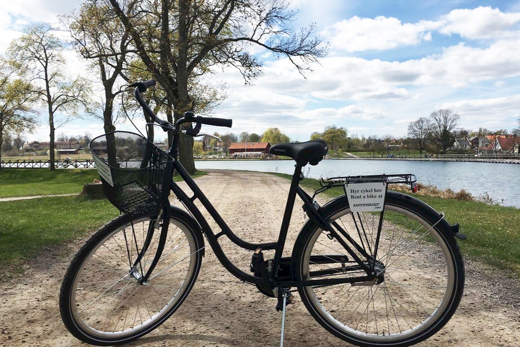 En svart cykel från Kaffeteriet i Borensberg står bredvid Göta kanal